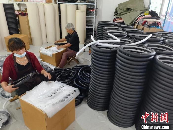 圖為村民在汽車飾品企業(yè)生產(chǎn)車間中工作。　呂子豪 攝