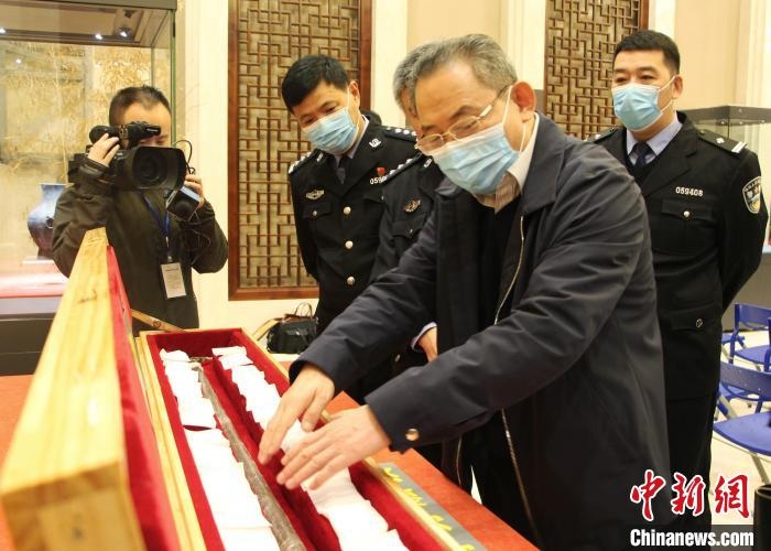 山東博物館館長(zhǎng)鄭同修介紹涉案文物龍首錯(cuò)銀木柲銅杖。　趙曉 攝