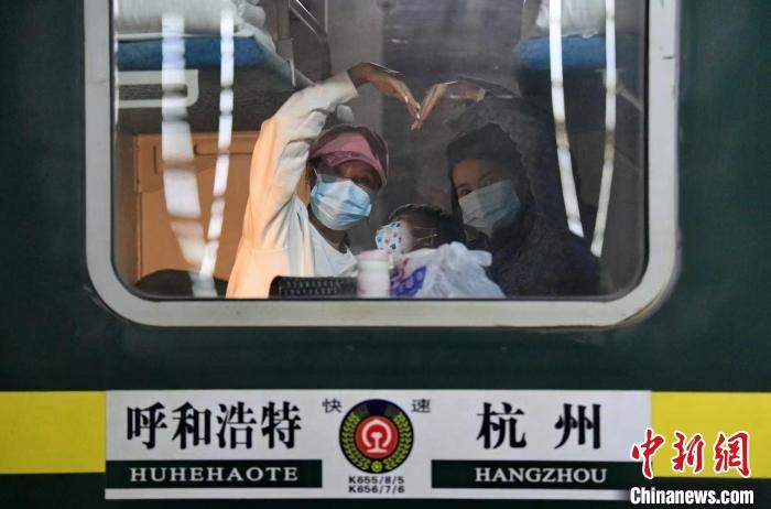 圖為登上轉(zhuǎn)運(yùn)火車的游客向額濟(jì)納比心?！⊥趵?攝