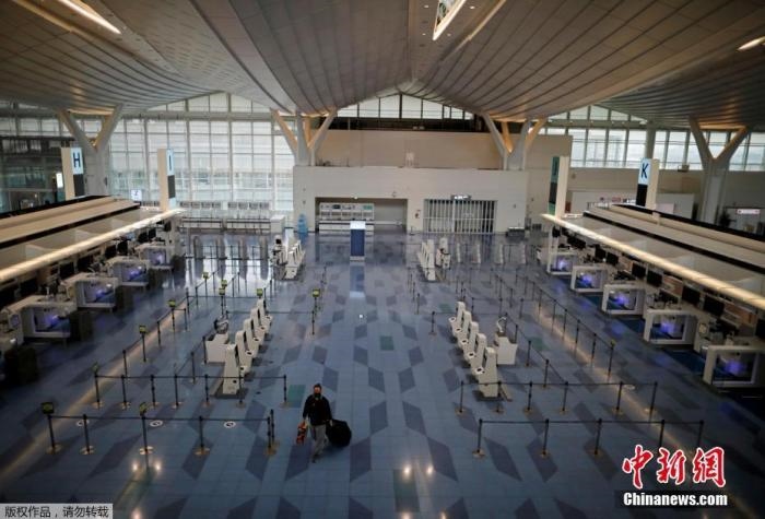 資料圖：日本東京，東京國(guó)際機(jī)場(chǎng)，一名乘客在國(guó)際航班航站樓的登機(jī)區(qū)。