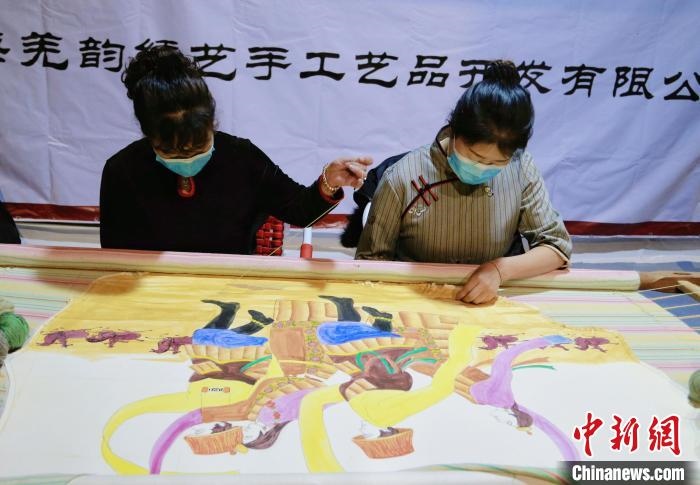 圖為皮繡藝人在市集上“秀”指尖技藝?！●R銘言 攝