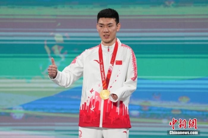 3月6日，梁景怡在延慶頒獎廣場領(lǐng)獎臺上豎起大拇指。當日，在國家高山滑雪中心舉行的北京2022年冬殘奧會殘奧高山滑雪男子超級大回轉(zhuǎn)—站姿決賽中，中國選手梁景怡奪得冠軍。 <a target='_blank' href='/'>中新社</a>記者 楊華峰 攝