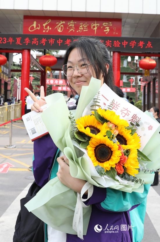 6月7日高考首日，山東67萬(wàn)考生走進(jìn)考場(chǎng)，拼搏逐夢(mèng)。在山東省實(shí)驗(yàn)中學(xué)考點(diǎn)，考生進(jìn)考場(chǎng)前手捧向日葵花拍照留念，寓意“一舉奪魁”。人民網(wǎng)記者 劉祺攝