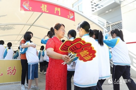 6月7日一早，雄安新區(qū)安新中學(xué)老師在給同學(xué)們加油鼓勁兒。人民網(wǎng) 李兆民攝
