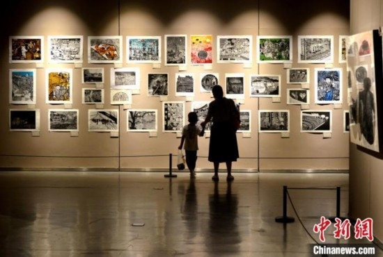 圖為家長(zhǎng)帶著孩子參觀展覽。呂明 攝