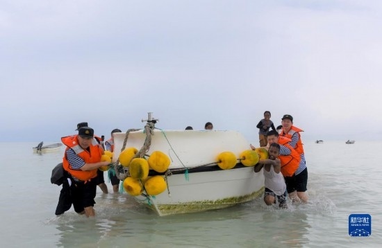 7月21日，中國(guó)海軍“和平方舟”號(hào)醫(yī)院船醫(yī)護(hù)人員涉水登島，前往基里巴斯一診療點(diǎn)。新華社記者 黎云 攝