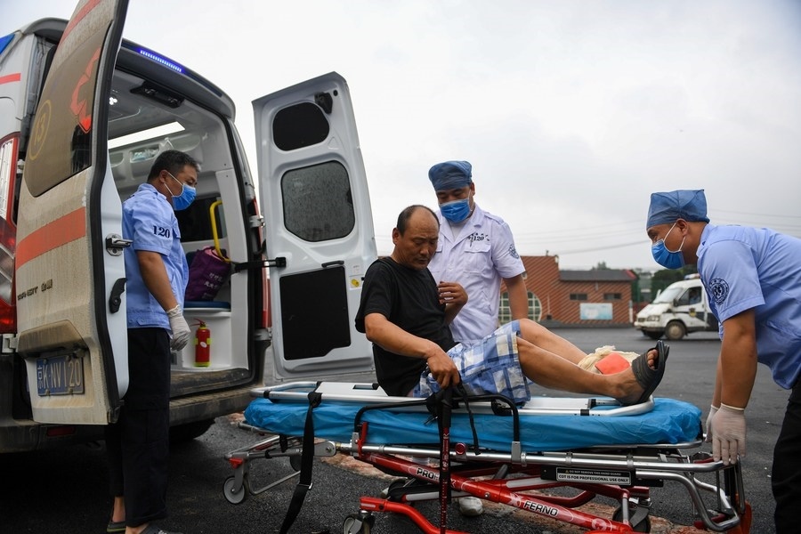 8月1日，在北京市門頭溝區(qū)妙峰山鎮(zhèn)妙峰山民族學(xué)校臨時安置點，北京急救中心工作人員在轉(zhuǎn)運一名受傷村民。新華社記者 鞠煥宗 攝