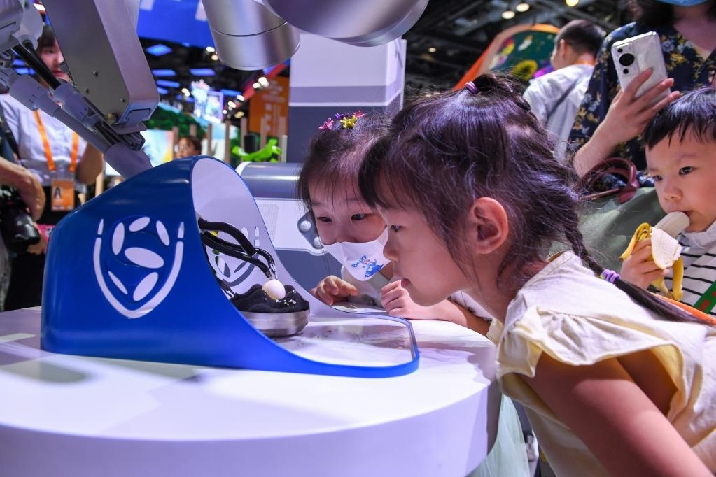 9月3日，幾名小朋友在國家會(huì)議中心觀看單孔腔鏡手術(shù)機(jī)器人展示。新華社記者 鞠煥宗 攝