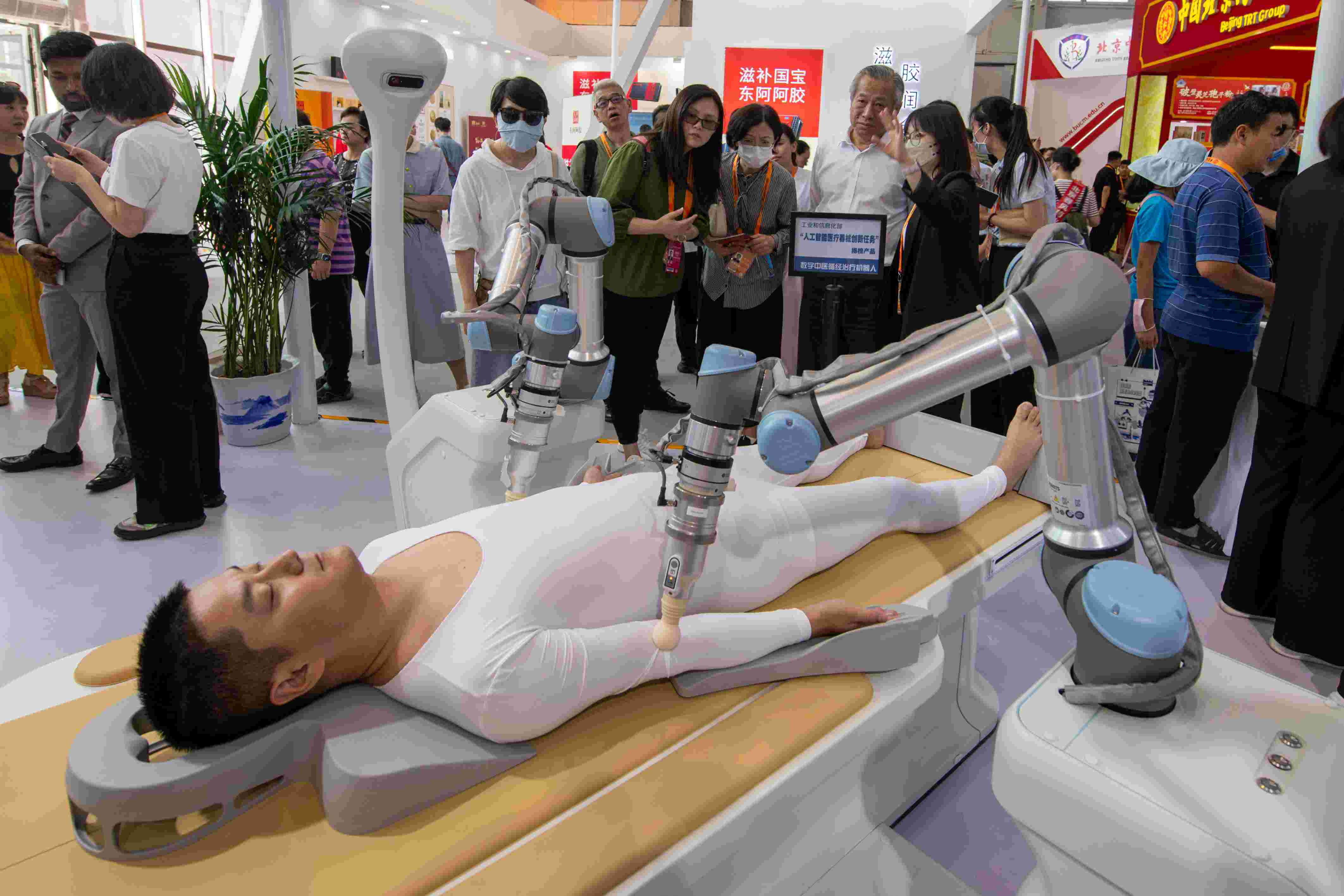 在位于首鋼園的健康衛(wèi)生服務(wù)展區(qū)，觀眾正在參觀數(shù)字中醫(yī)循經(jīng)治療機(jī)器人。人民網(wǎng)記者 翁奇羽攝