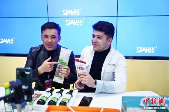 2023年3月，甘肅省慶陽市環(huán)縣電商創(chuàng)業(yè)孵化基地內，來自蘭州文理學院的塔吉克斯坦留學生正在協助主播直播帶貨當地農特產品。李亞龍 攝