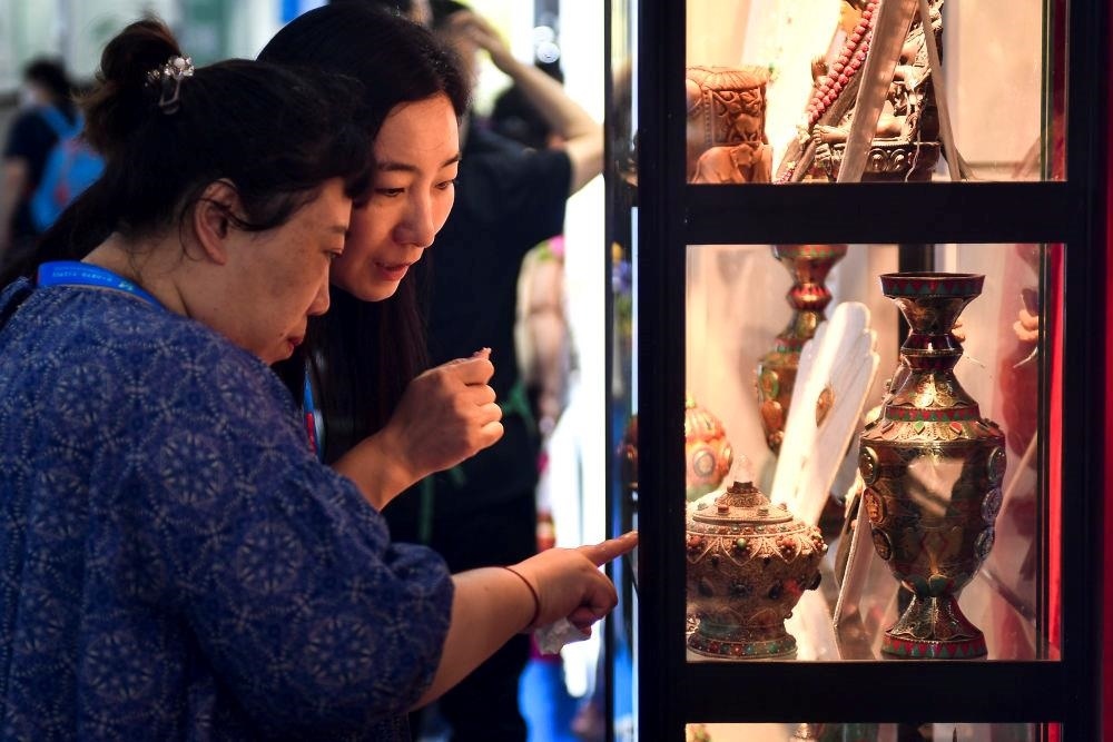 △2023年8月24日，參觀者在第十四屆中國—東北亞博覽會現(xiàn)場選購尼泊爾特色商品。