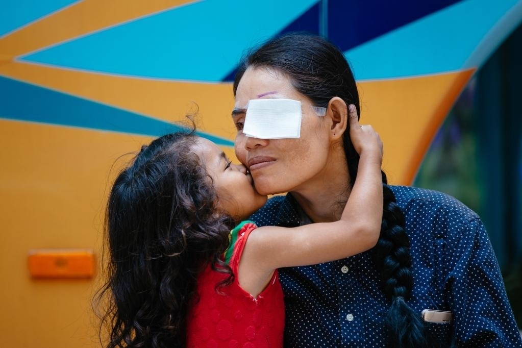 2019年3月15日，在柬埔寨磅湛省醫(yī)院，即將接受白內障手術的患者孫美樂接受女兒的親吻祝福。在接受了中國醫(yī)療隊的白內障義診手術后，她的視力逐步恢復，生活有了新的光明和希望。