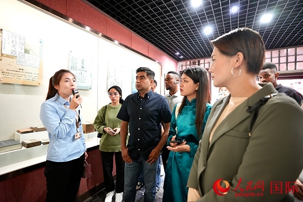 選手們認(rèn)真聆聽導(dǎo)游講解。人民網(wǎng) 盧鵬宇攝