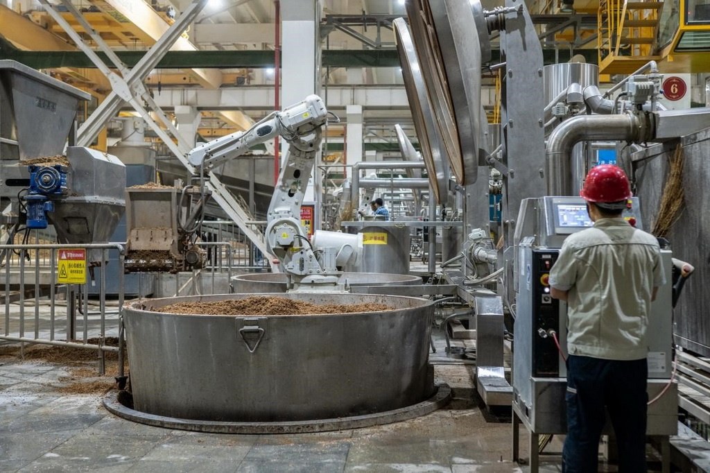 907車間里，機械臂正在撒料裝甑。嚴(yán)磊攝