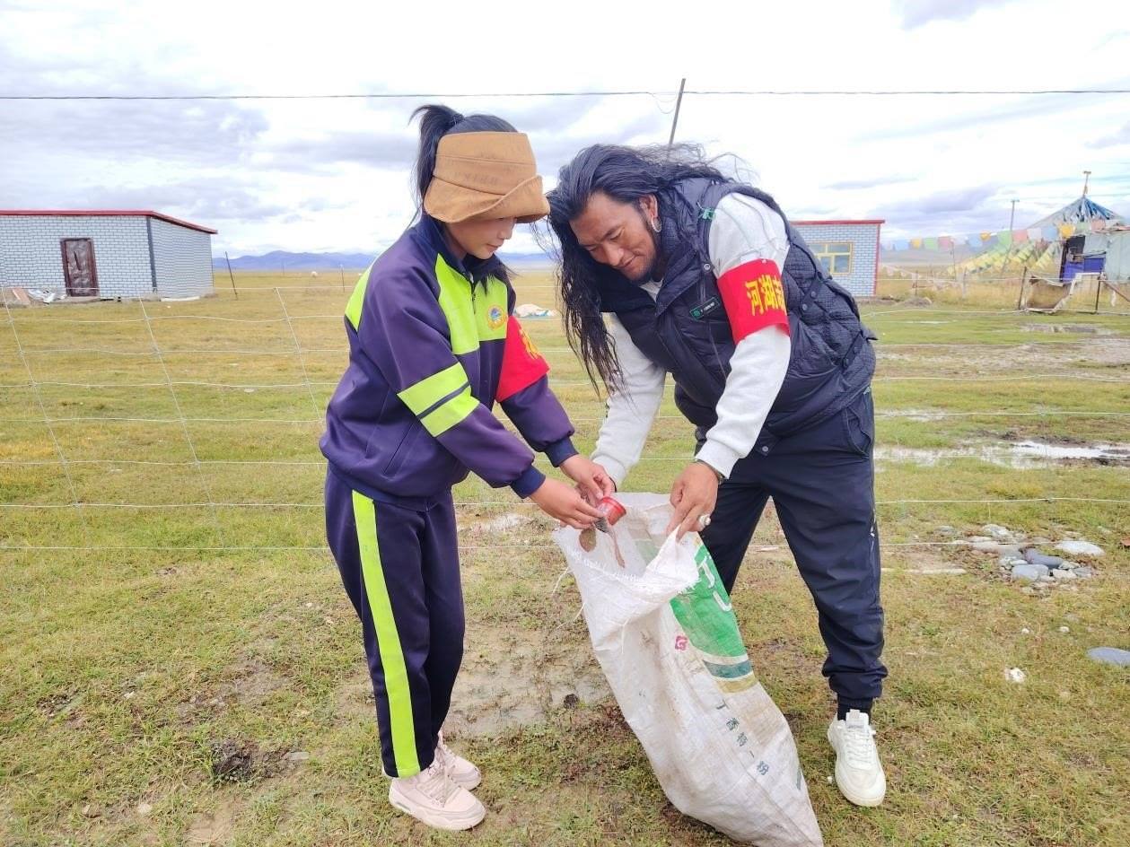 玉樹州稱多縣珍秦鎮(zhèn)河湖志愿者才培和他女兒更求拉毛在清掃垃圾。受訪者供圖