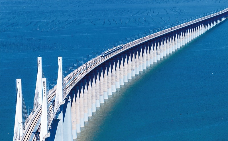 2023年9月28日，中國首條時速350公里跨海高鐵——福廈高鐵正式開通運營。圖為一列運行試驗車組駛過福廈高鐵湄洲灣跨海大橋（9月19日攝，無人機照片）。 新華社記者 魏培全/攝