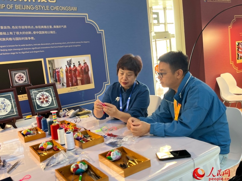 記者在新聞中心非遺傳承人展區(qū)進行體驗。人民網(wǎng)記者 杜燕飛攝