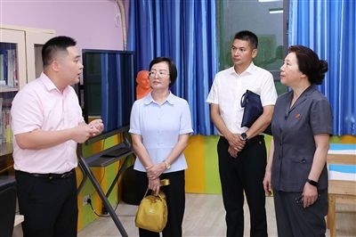 圖③：“小公民法律課堂”開講前，全國(guó)人大代表殷其龍（右二）、重慶市人大代表李自玲（左二）聽取楊家坪中學(xué)負(fù)責(zé)人關(guān)于未成年人思想教育工作情況的介紹。