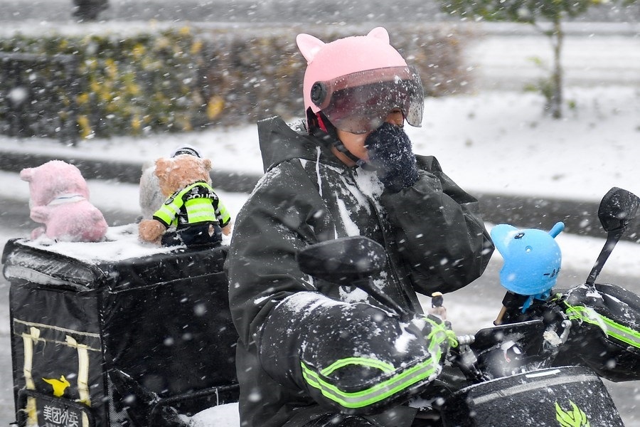 11月6日，在長春市街頭，一名外賣員在雪中騎行。新華社記者 許暢 攝