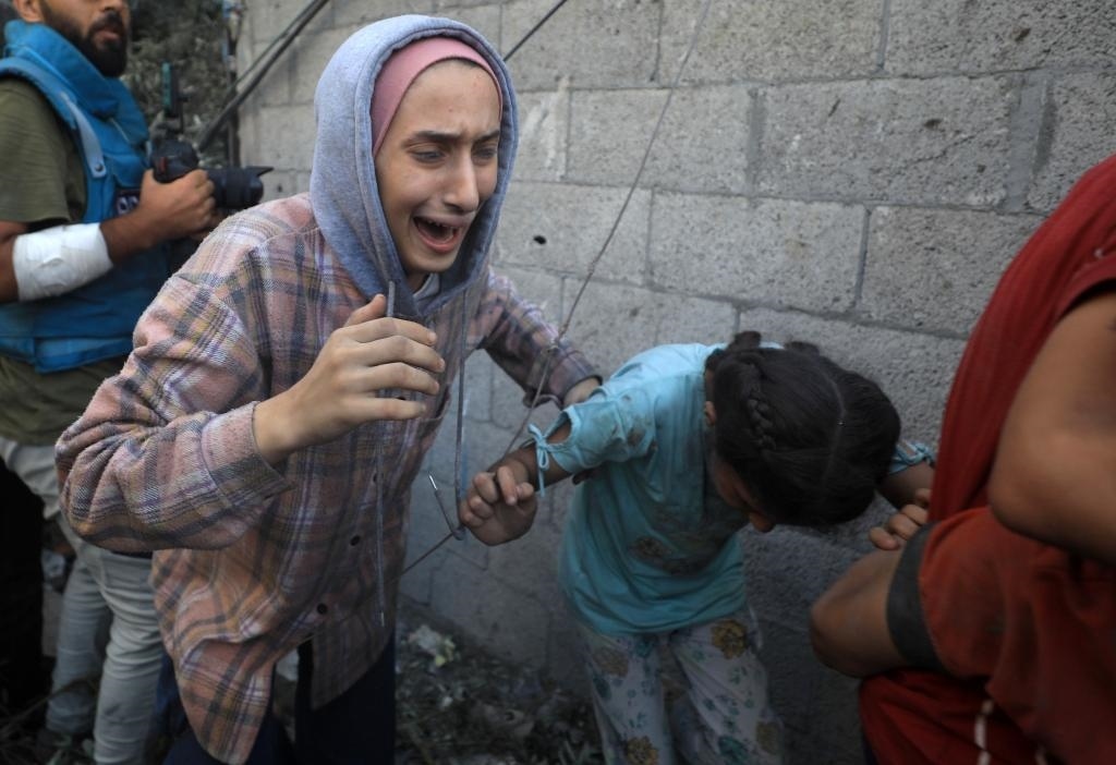 11月6日，人們從加沙地帶中部地區(qū)一處被炸難民營逃離。新華社發(fā)（亞西爾·庫迪攝）