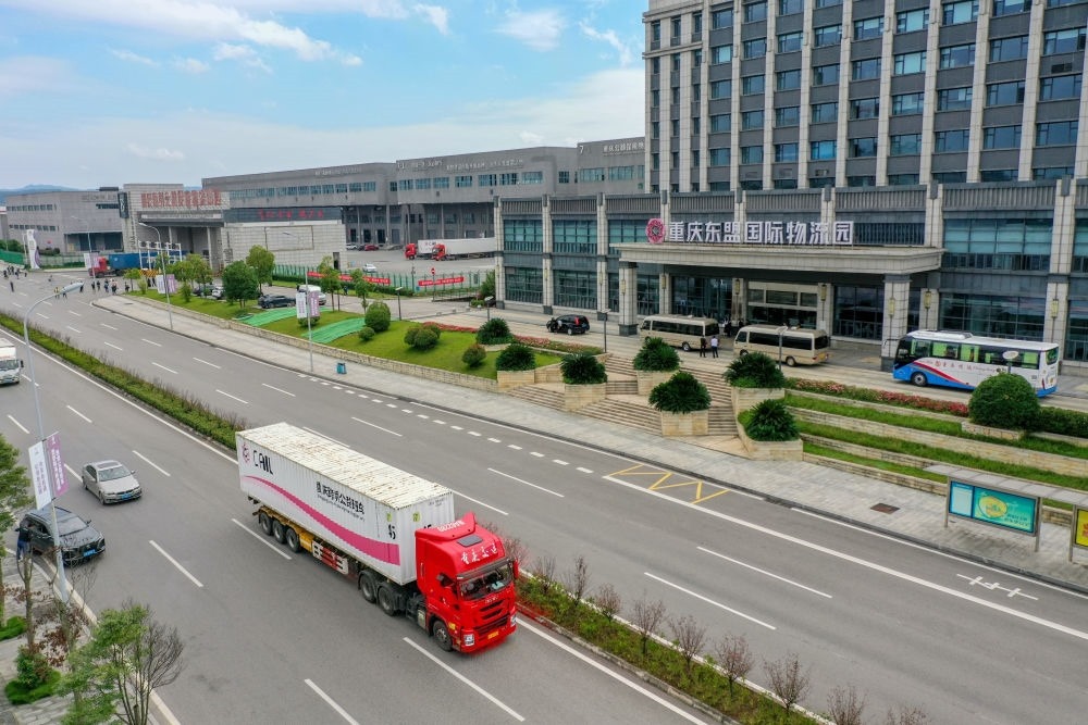 2023年10月11日，滿載筆記本電腦配件、發(fā)電機(jī)組件等產(chǎn)品的西部陸海新通道跨境公路班車(chē)從重慶南彭公路保稅物流中心駛出，將途經(jīng)廣西憑祥，直達(dá)越南（無(wú)人機(jī)照片）。新華社記者 黃偉 攝