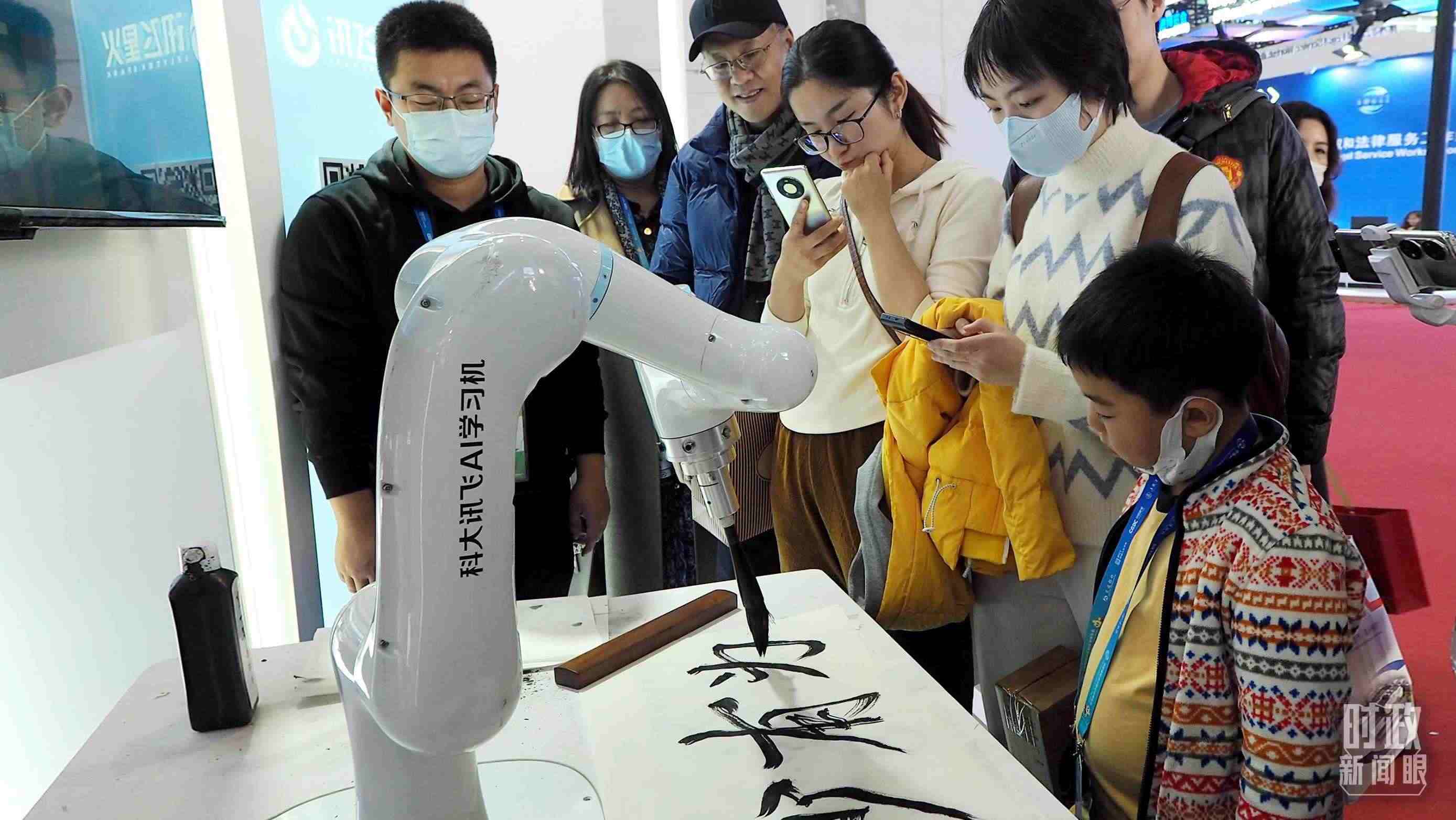 △觀眾在首屆鏈博會(huì)上體驗(yàn)AI書法機(jī)器人。