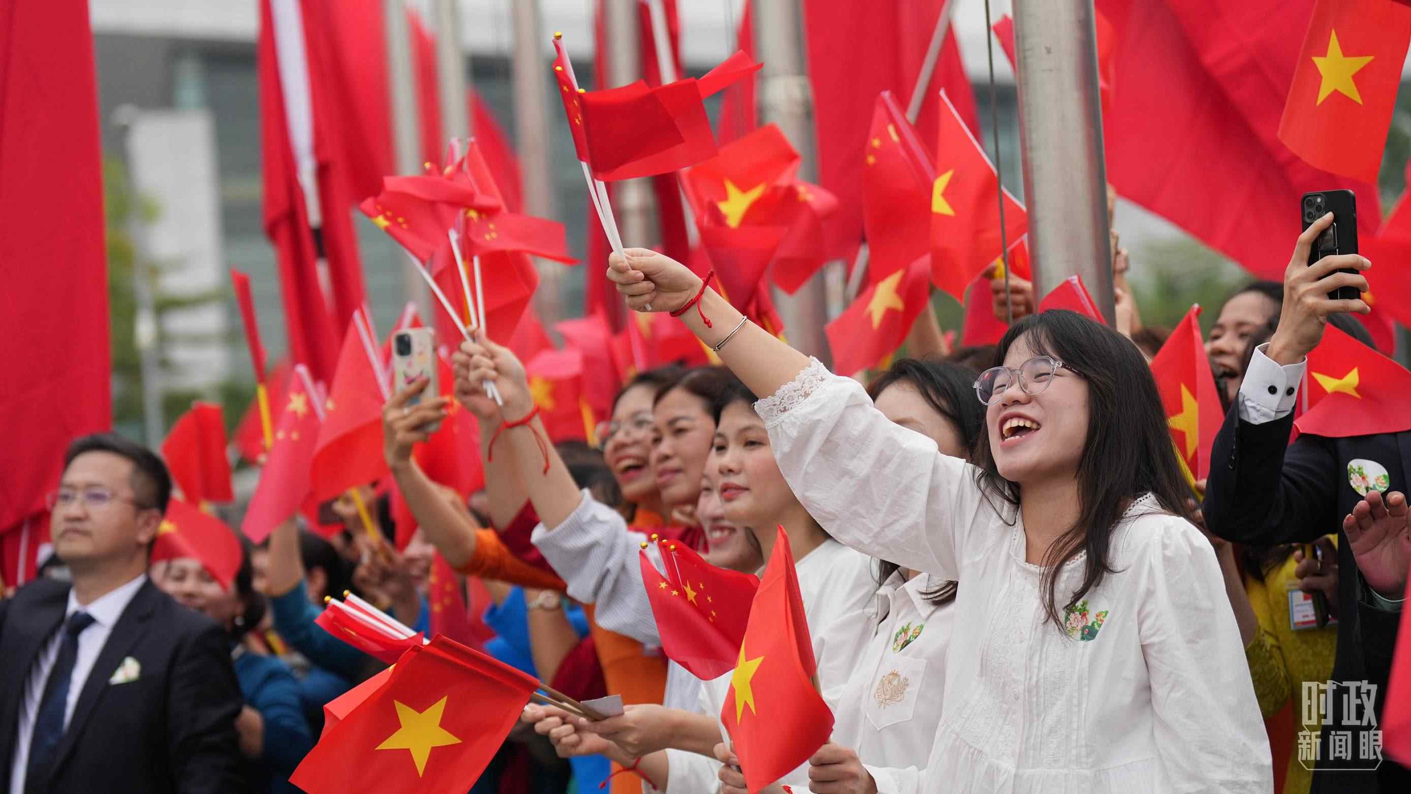 △人們揮舞兩國旗幟歡迎習(xí)近平訪越。（總臺國廣記者李晉拍攝）