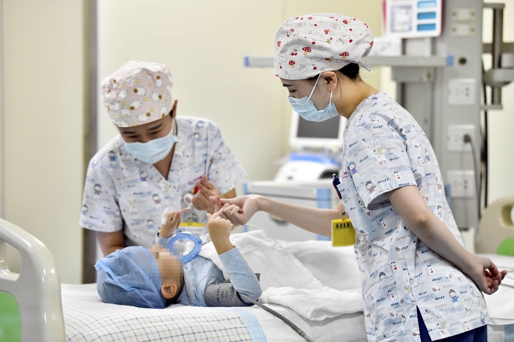 在山東省棗莊市婦幼保健院兒童ICU病房，醫(yī)護(hù)人員為完成靶向治療藥物諾西那生鈉的4歲脊髓性肌萎縮癥患兒加油鼓勁（2022年1月1日攝）。諾西那生鈉注射液是我國首個獲批治療脊髓性肌萎縮癥的進(jìn)口藥物，2019年進(jìn)入中國市場時，每針價格近70萬元。在2021年國家醫(yī)保目錄藥品談判中，以3.3萬元每針的價格進(jìn)入新版醫(yī)保藥品目錄。新華社記者 郭緒雷 攝