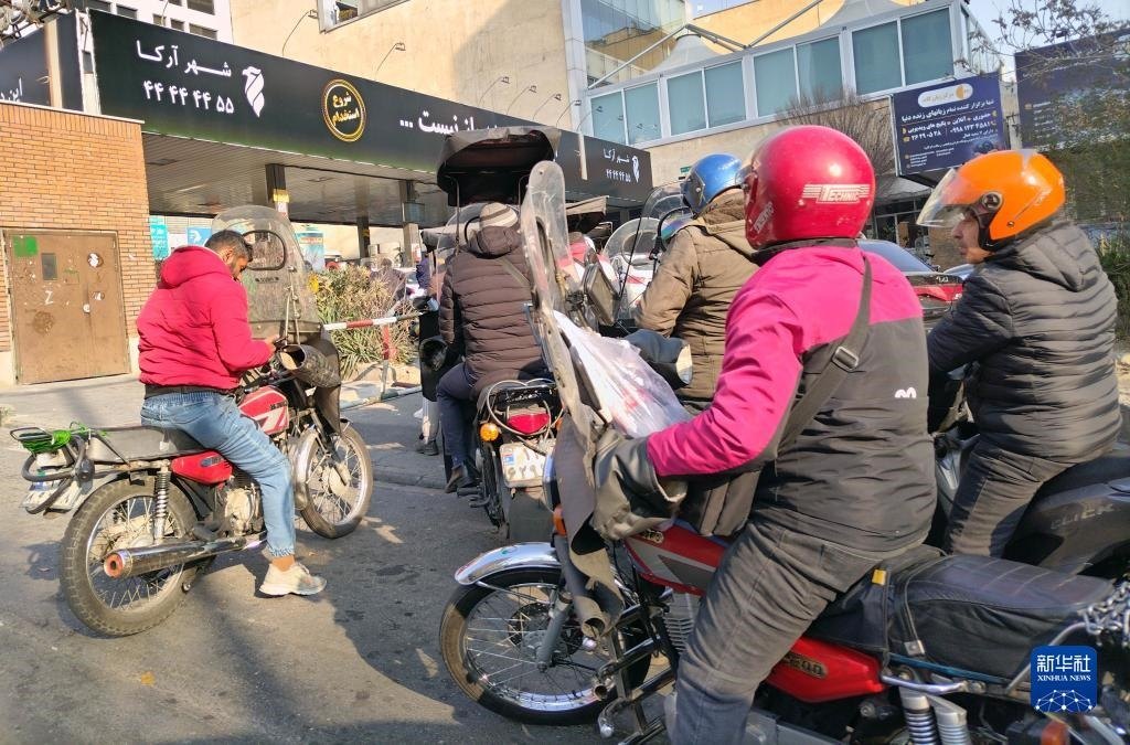 12月18日，摩托車在伊朗首都德黑蘭的一家加油站外等待加油。新華社記者 沙達(dá)提 攝