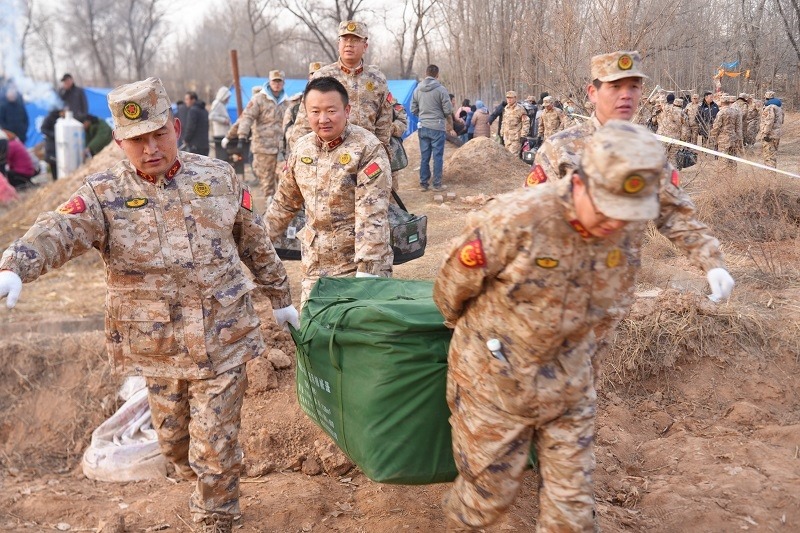 救援人員正在現場緊急搬運物資。賀勇攝。