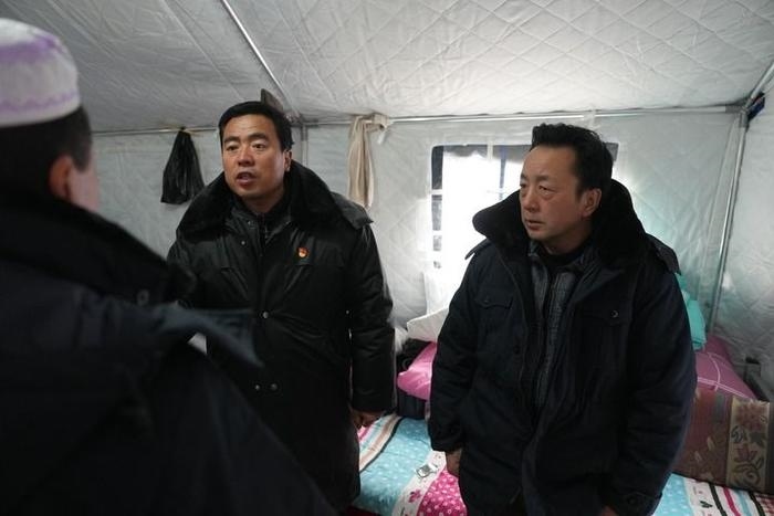 2023年12月22日，積石山縣大河家鎮(zhèn)大河村黨支部書記馬成忠（右二）在帳篷里和受災(zāi)群眾交流。新華社記者 陳斌 攝