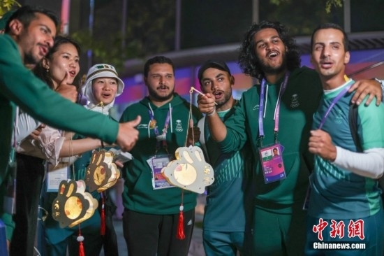 資料圖：9月29日，中國傳統(tǒng)節(jié)日中秋節(jié)，杭州亞運(yùn)會(huì)運(yùn)動(dòng)員村舉辦中秋主題活動(dòng)，中外運(yùn)動(dòng)員們歡聚一堂。圖為沙特阿拉伯運(yùn)動(dòng)員手持燈籠拍攝照片。<a target='_blank' href='/'><p align=