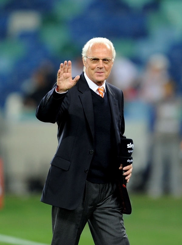 這是2010年7月7日，在南非德班舉行的2010年足球世界杯德國隊對陣西班牙隊的半決賽前，貝肯鮑爾接受電視臺采訪時和友人打招呼。新華社記者 王毓國 攝