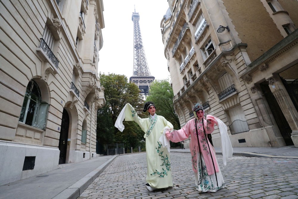 2023年9月13日，江蘇省演藝集團(tuán)昆劇院院長(zhǎng)施夏明（左）和江蘇省演藝集團(tuán)昆劇院國(guó)家一級(jí)演員孔愛(ài)萍在法國(guó)巴黎埃菲爾鐵塔附近參加昆曲快閃。新華社記者 高靜 攝