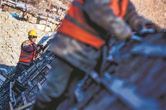 1月3日，房山區(qū)，工人正在雙泉河修筑堤壩。