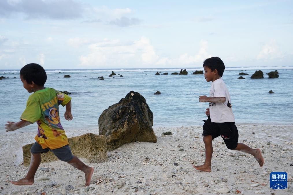 1月20日，兒童在瑙魯海邊嬉戲。新華社記者 王申 攝