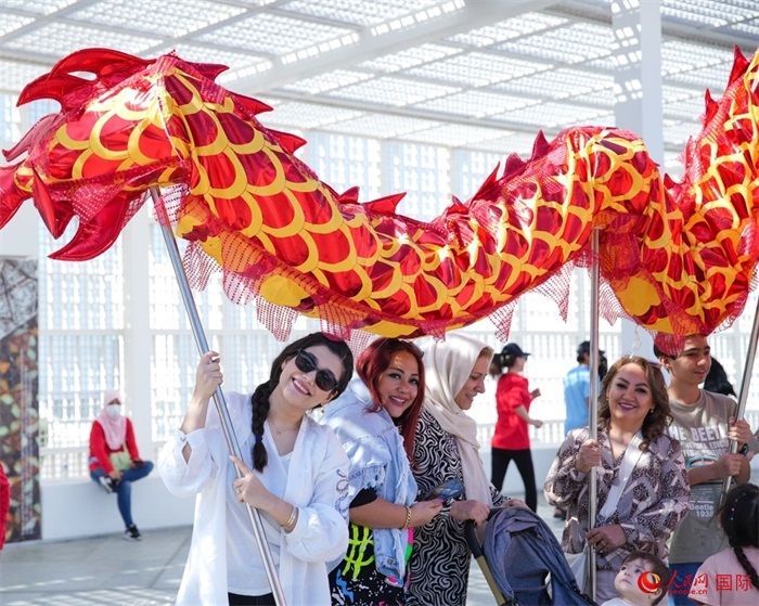 游客體驗舞龍。 人民網(wǎng) 塔里克·易卜拉欣攝