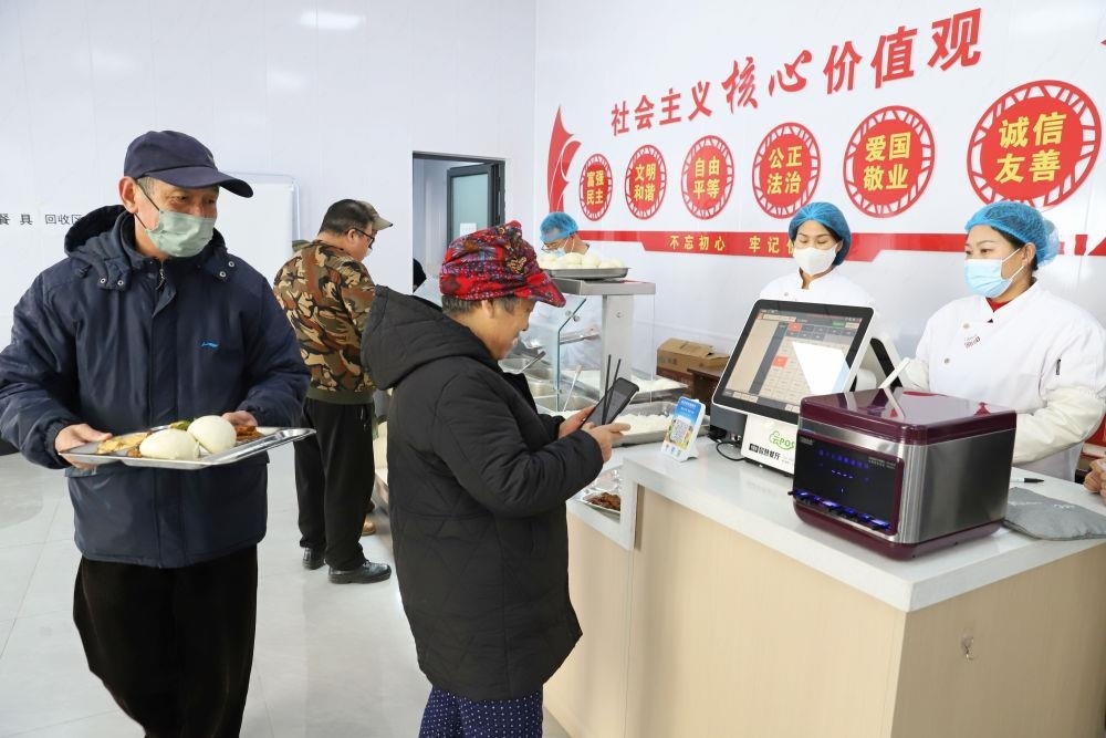 △2024年2月1日，市民在河北涿州市雙塔街道永濟(jì)秀園小區(qū)便民食堂內(nèi)購買午餐。