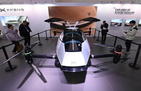 2023年12月1日，在鏈博會(huì)智能汽車鏈展區(qū)小鵬汽車展臺(tái)，參觀者觀看一臺(tái)智能飛行器。新華社記者蔡湘鑫攝