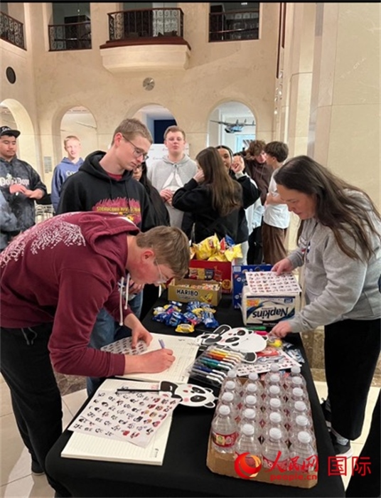 學生們出發(fā)前紛紛在留言簿留言。人民網(wǎng)記者 鄧圩攝