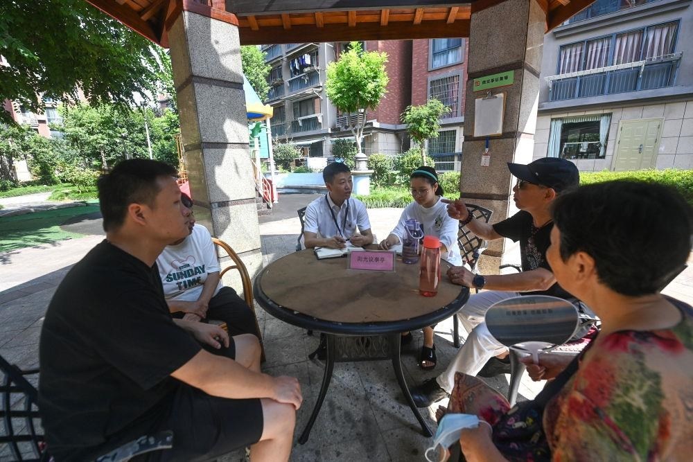 △2023年7月21日，在位于浙江杭州臨安區(qū)錦南街道水岸陽光小區(qū)的陽光議事廳，街道干部在聽取居民們反映的問題及意見。