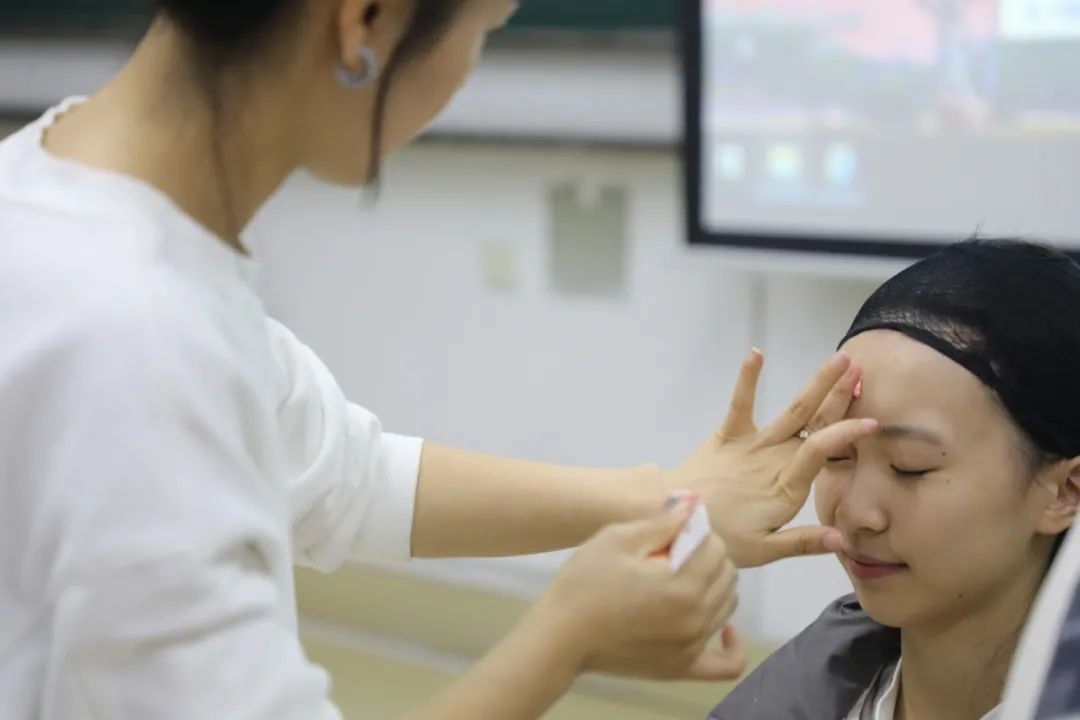 課堂上，一名學(xué)生在體驗(yàn)上戲妝。學(xué)校供圖