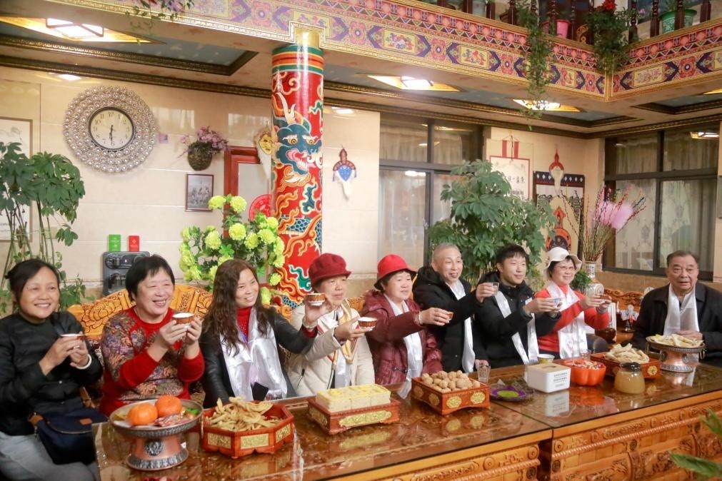 游客們?nèi)胱∶袼藓?，舉杯共飲酥油茶。新華社記者 邱星翔 攝