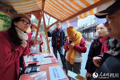 1月6日，“2024成都蒲江柑甜采摘節(jié)”上，記者見到了小萌（左一）和許多年輕人忙著做訪客接待、現(xiàn)場布置、票務(wù)核對、采摘服務(wù)等工作。人民網(wǎng)記者朱虹攝