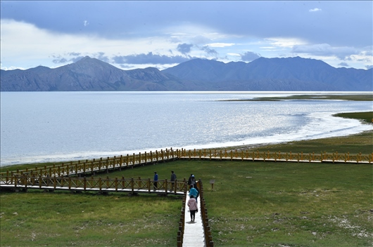 △ 游客行走在青?，敹嗫h冬格措納湖畔的木棧道上。