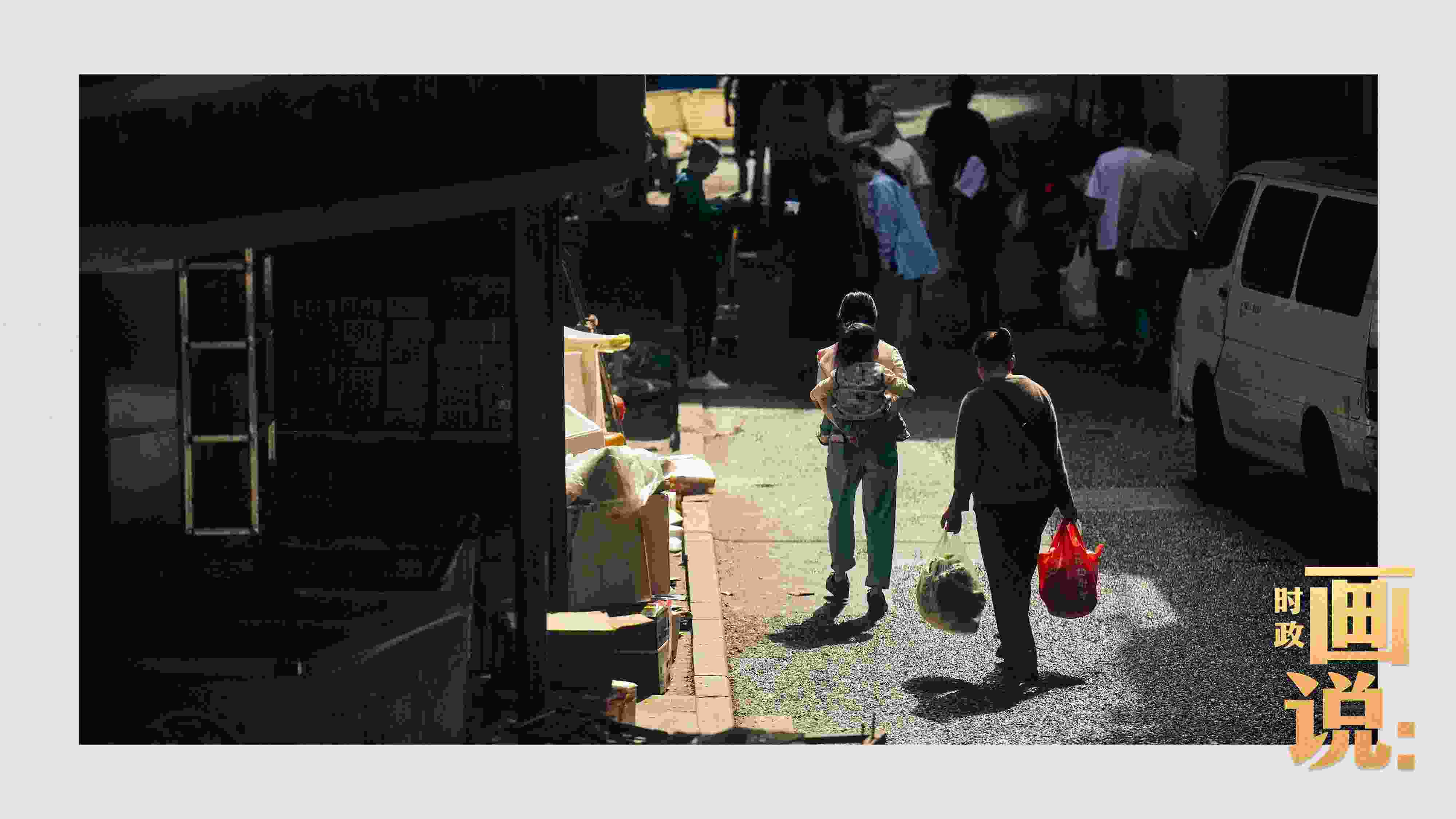 △老城區(qū)鱗次的樓宇間漏下一縷光，路人走過(guò)暖陽(yáng)。