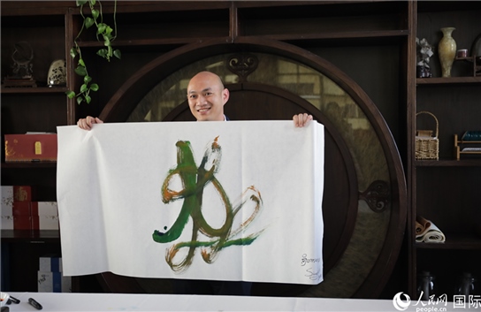 老撾駐華大使館三秘明君參加《五百筆·瀾湄合作》集體藝術(shù)創(chuàng)作。人民網(wǎng)王婧攝。