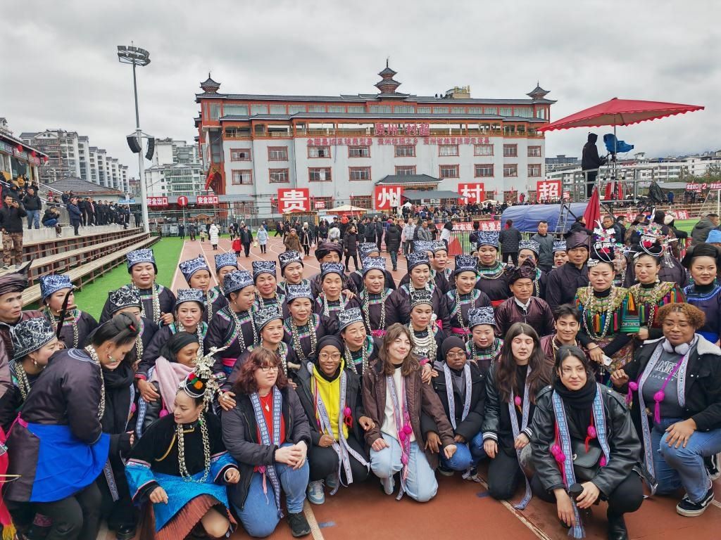 法國青年在“村超”賽場邊與參加表演的村民合影。新華社記者 羅羽 攝