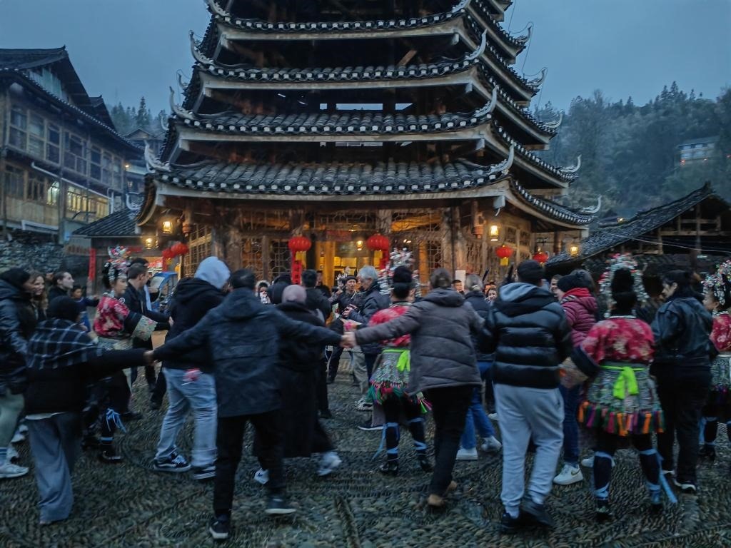 法國青年與當(dāng)?shù)卮迕駹渴痔?。新華社記者 羅羽 攝