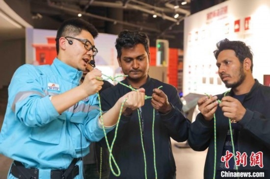 5月9日，工作人員指導(dǎo)留學(xué)生學(xué)習(xí)打繩結(jié)。張鷹 攝